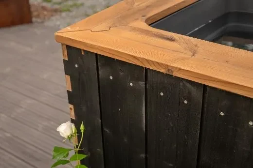 Mustaksi käsitelty lämpöpuupaneeli tuo tyylikkyyttä pihapiiriin.